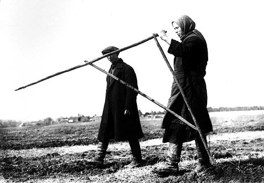 Peasants measuring their plots of land with a field compass.